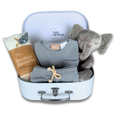 Baby gift set with clothes, swaddle, and plush toy in a suitcase on a white background